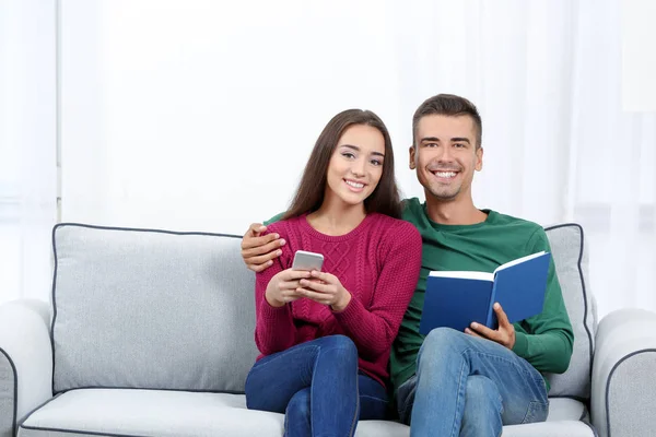 Giovane coppia sul divano di casa — Foto Stock