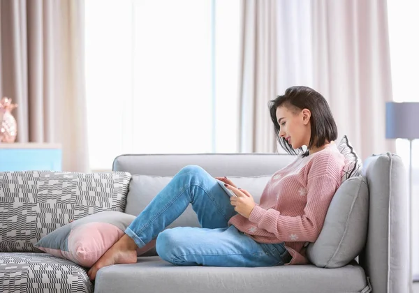 Jovem mulher usando tablet em casa — Fotografia de Stock