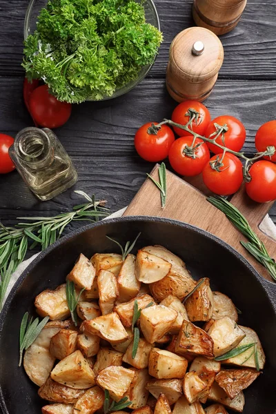 Compositie met heerlijke rozemarijn aardappelen in de pan — Stockfoto