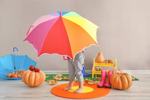 Adorável menina segurando guarda-chuva colorido dentro de casa — Fotografia de Stock