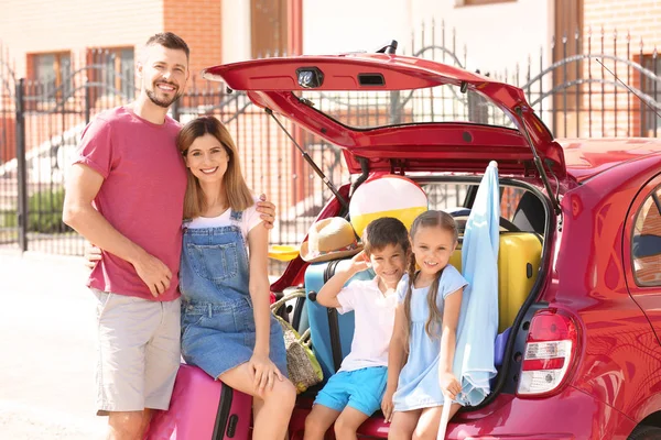 Family near car with things prepared for rest at sea resort