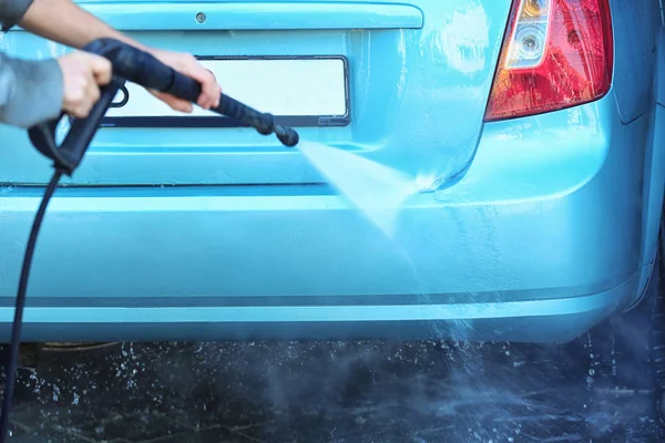 Hombre de limpieza de automóviles con agua de alta presión en el lavado de coches — Foto de Stock