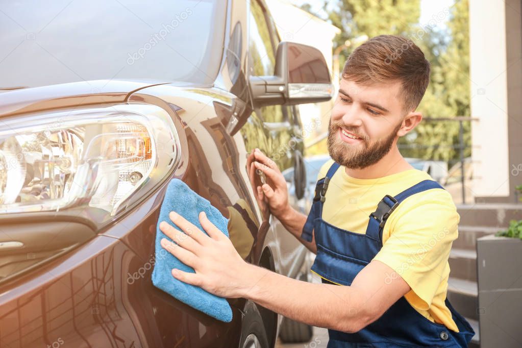 Man cleaning car with rag outdoors
