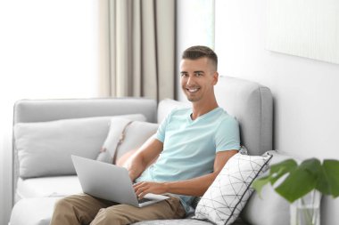 Genç adam dizüstü bilgisayar kullanıyor 