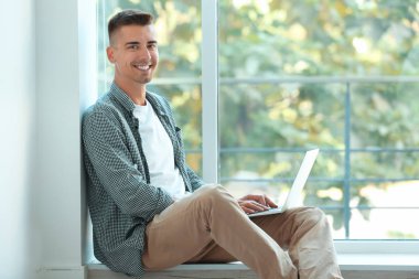 Genç adam dizüstü bilgisayar kullanıyor 