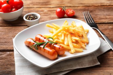 Plaka lezzetli ızgara sosis ve patates kızartması ile