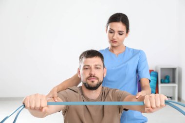 Fizyoterapist klinikte genç erkek hasta ile çalışma