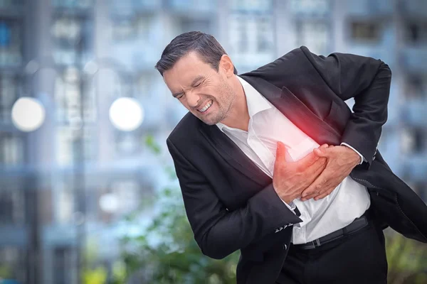 Biznesmen, cierpiących na ból w klatce piersiowej na zewnątrz — Zdjęcie stockowe