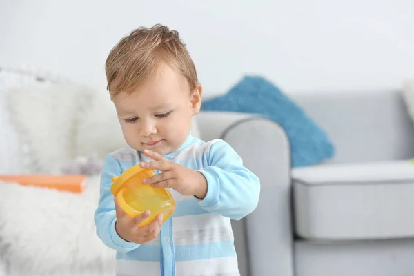 Adorable baby with drinking bottle at home — Stock Photo, Image