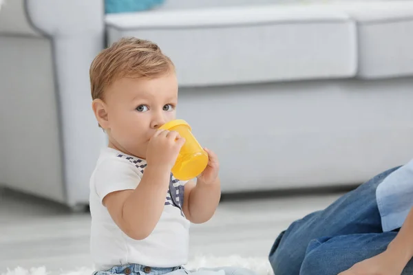 Adorable baby with drinking bottle at home — Stock Photo, Image