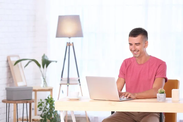 Hombre joven usando el ordenador portátil — Foto de Stock