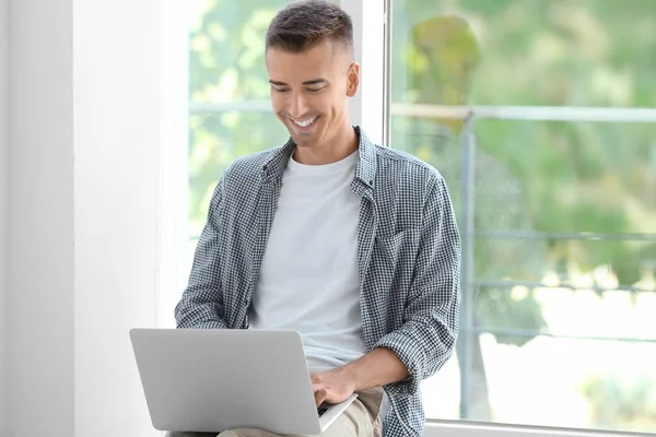 Hombre joven usando el ordenador portátil — Foto de Stock