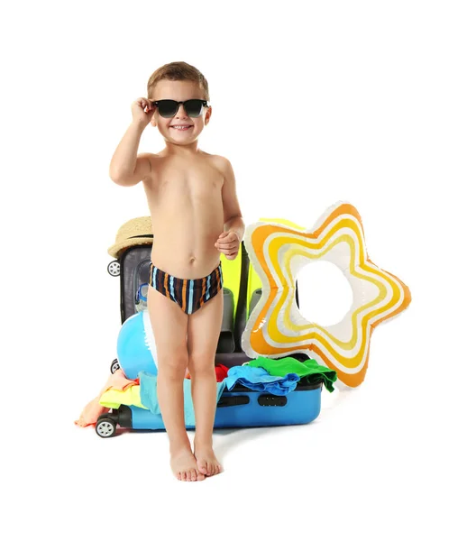 Lindo niño pequeño con maleta y accesorios de playa sobre fondo blanco — Foto de Stock