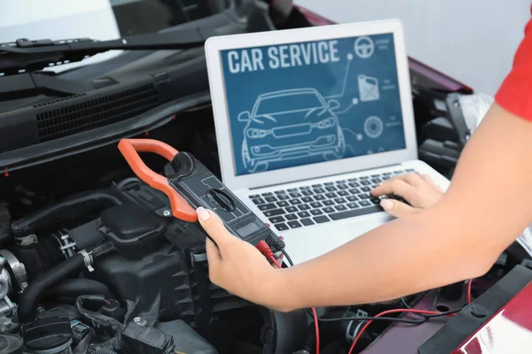 Joven mecánico femenino con portátil de reparación de coches en el taller de carrocería —  Fotos de Stock