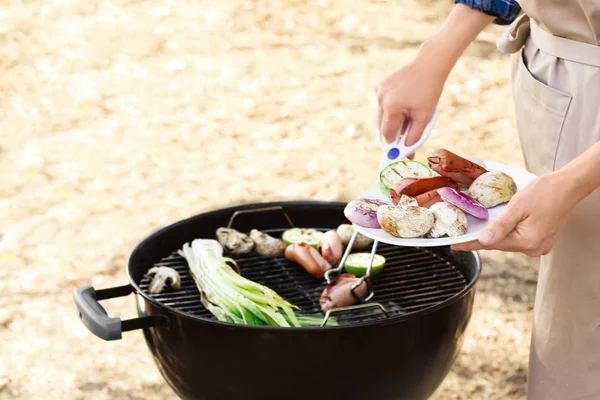 Kvinne som lager gode pølser med grønnsaker – stockfoto