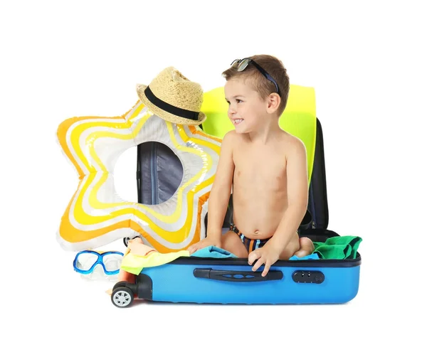 Lindo niño pequeño con maleta y accesorios de playa sobre fondo blanco — Foto de Stock