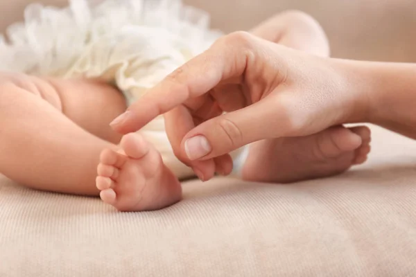 Mother touching baby feet — Stock Photo, Image