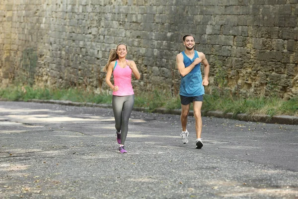 Young man and woman running in city — Stock Photo, Image