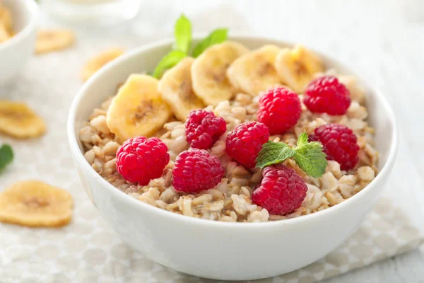 Aveia saborosa com frutas na tigela na mesa — Fotografia de Stock