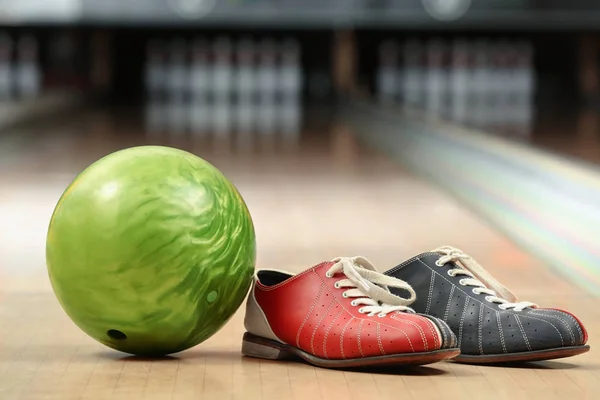 Zapatos y pelota en el suelo en el club de bolos — Foto de Stock