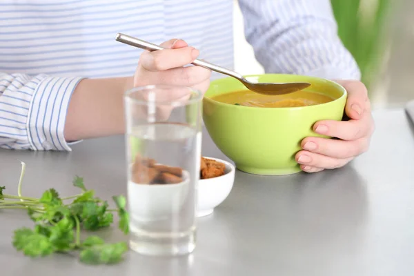 Vrouw met kom en lepel met zelfgemaakte linzen crème soep — Stockfoto