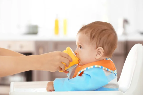 Madre dando biberón con agua en interiores — Foto de Stock