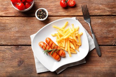 Plaka lezzetli ızgara sosis ve patates kızartması ile