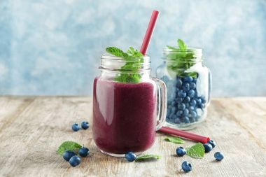 Mason kavanoz acai suyu ve ahşap masa üzerinde çilek ile