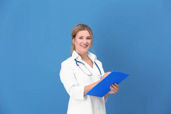 Doctor con portapapeles sobre fondo de color — Foto de Stock