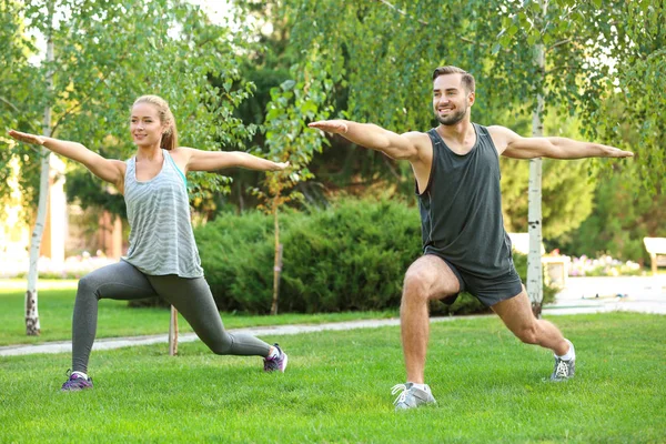 Joven hombre y mujer haciendo ejercicios en el parque — Foto de Stock