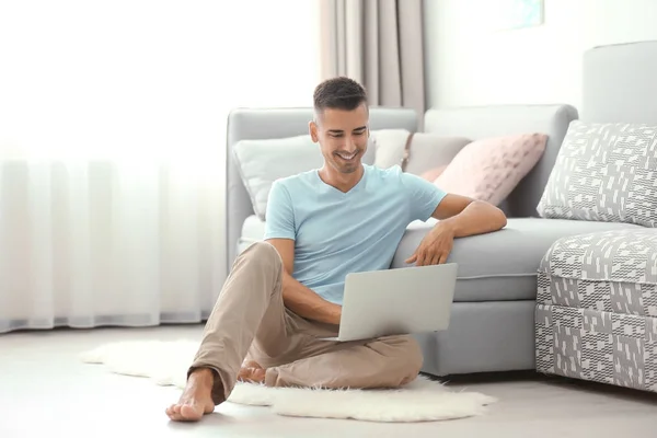 Hombre joven usando el ordenador portátil — Foto de Stock