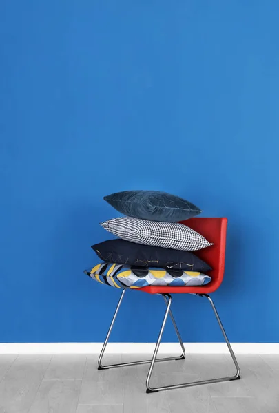 Chair with pillows near color wall — Stock Photo, Image