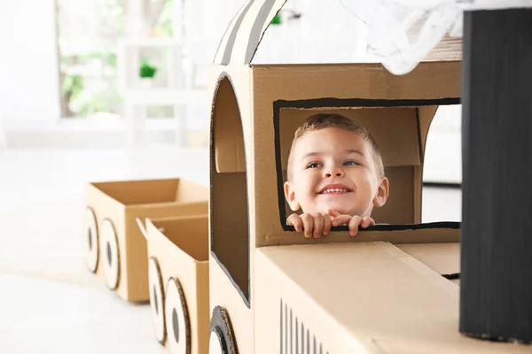 Little boy playing with cardboard train in light room — Stock Photo, Image