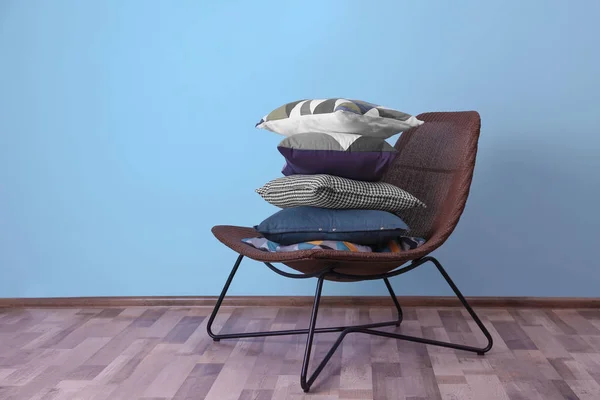 Armchair with pillows near color wall — Stock Photo, Image