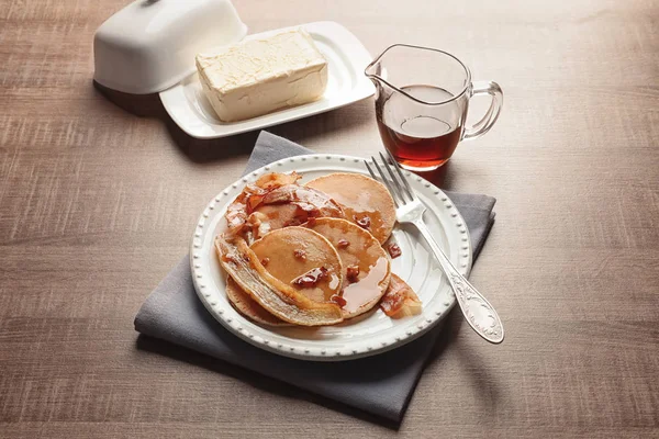 Plate with pancakes, bacon and fried banana on table — Stock Photo, Image