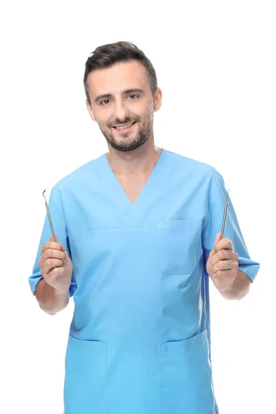 Мужчина стоматолог с инструментами на белом фоне — стоковое фото