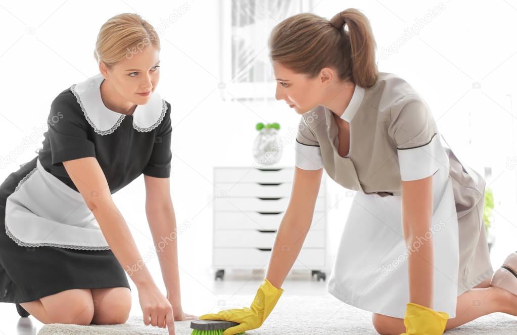 Chambermaid teaching trainee to clean 