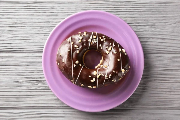 Тарелка с вкусным пончиком — стоковое фото