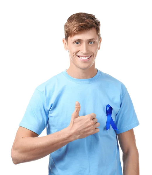 Junger Mann im T-Shirt mit blauer Schleife auf weißem Hintergrund. Prostatakrebs-Aufklärungskonzept — Stockfoto