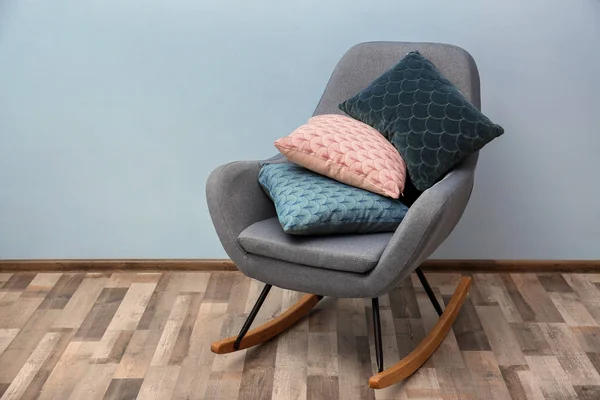 Качающее кресло с красочными подушками в помещении — стоковое фото