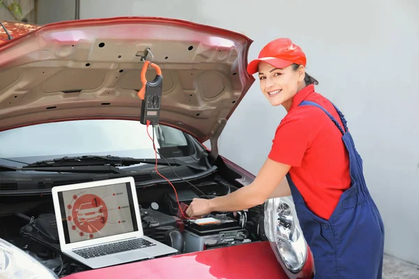 Joven mecánico femenino con portátil reparación de coches al aire libre — Foto de Stock
