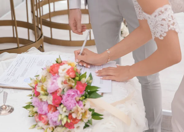 Bride signing marriage certificate