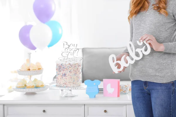 Kobieta w ciąży, trzymając wystrój na baby shower strony — Zdjęcie stockowe