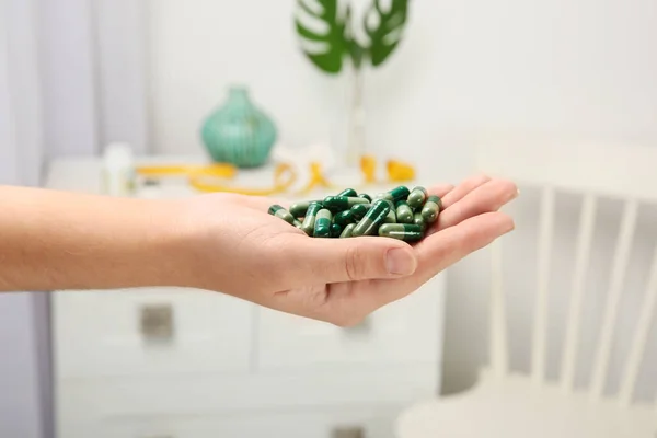 Woman holding spirulina capsules