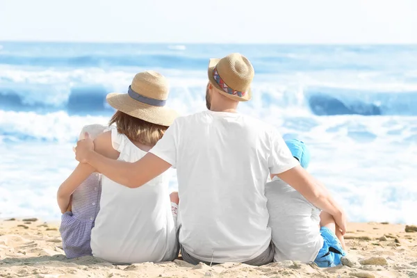 Lycklig familj sitter på stranden på resort — Stockfoto