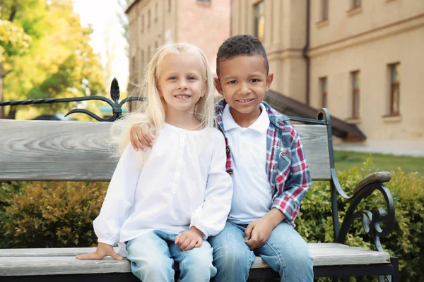 Cute fashionable children sitting on bench outdoors — Stock Photo, Image