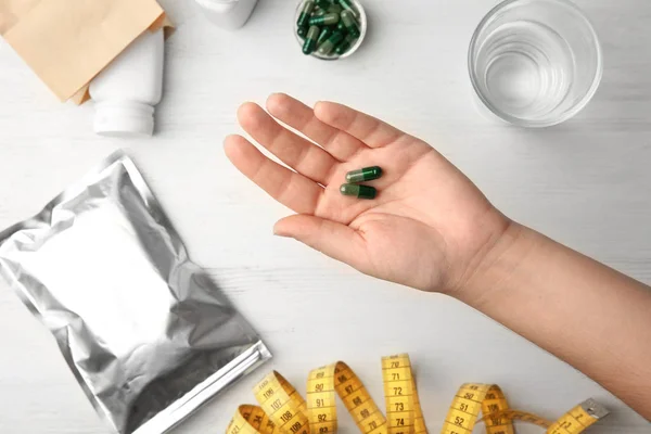 Mulher segurando cápsulas spirulina — Fotografia de Stock