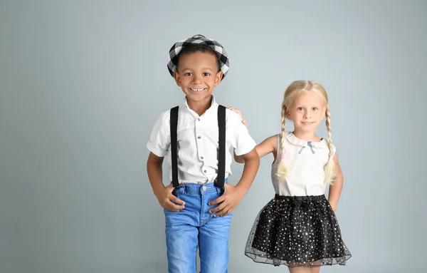 Bonito crianças na moda em fundo cinza — Fotografia de Stock
