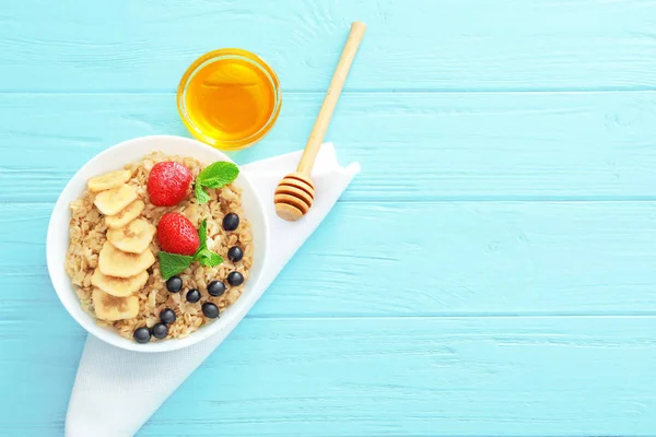 Farina d'avena saporita con bacche e frutta in ciotola sul tavolo — Foto Stock