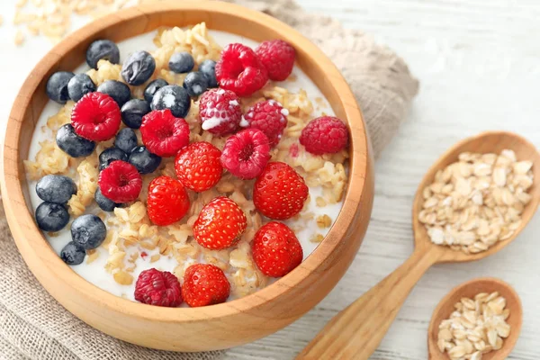 Tasty oatmeal with berries in bowl on table — Stock Photo, Image